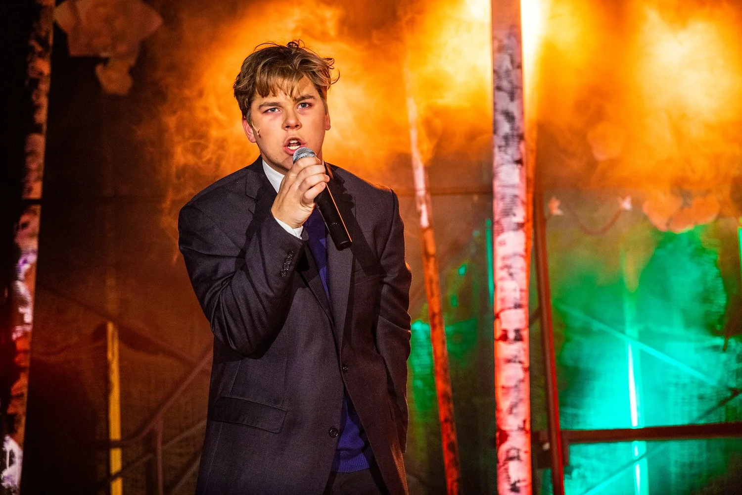 A singer performs in warm amber stage light